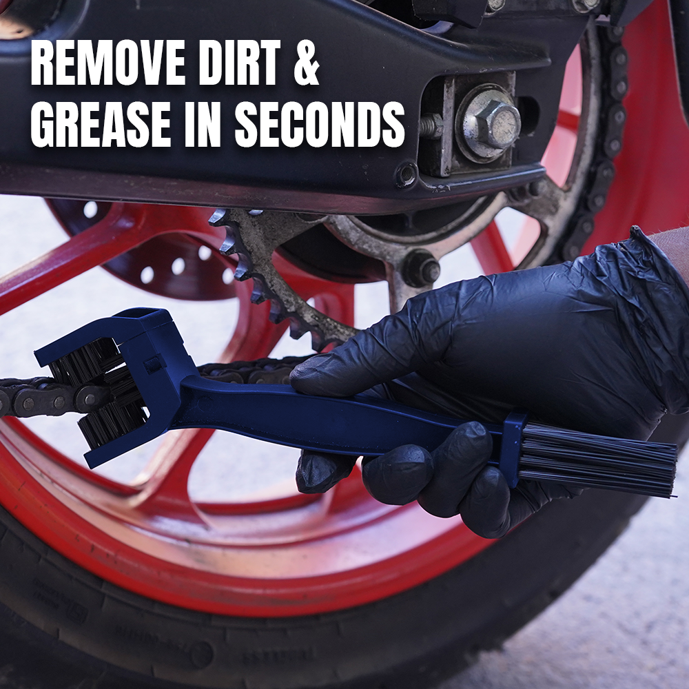 A close-up of a gloved hand using a blue chain cleaning tool on a motorcycle chain near a red wheel, with the text 'REMOVE DIRT & GREASE IN SECONDS' overlaid at the top.
